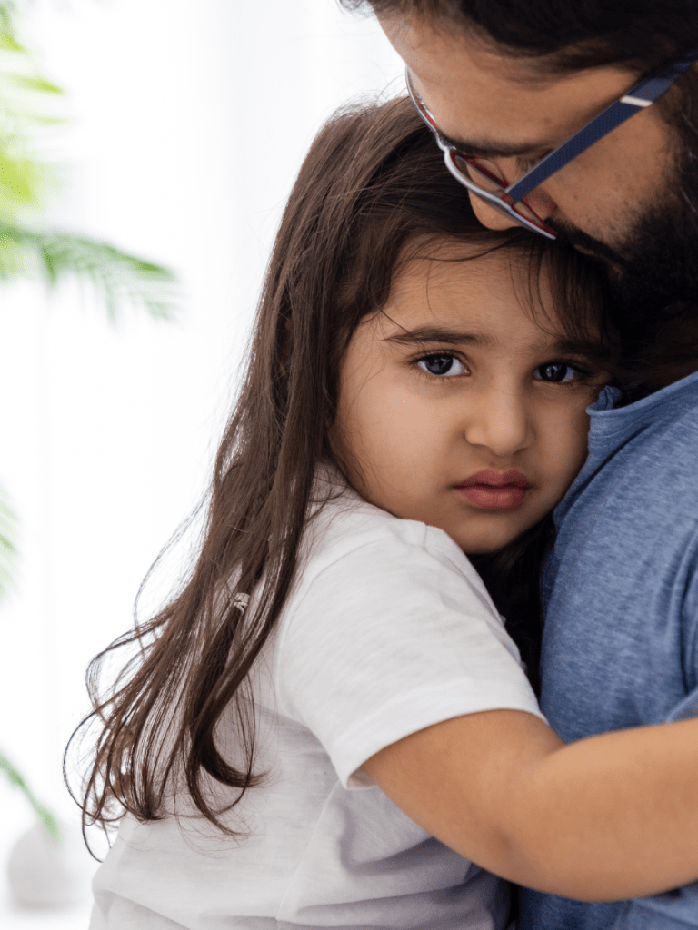 fearful girl on her dad's arms